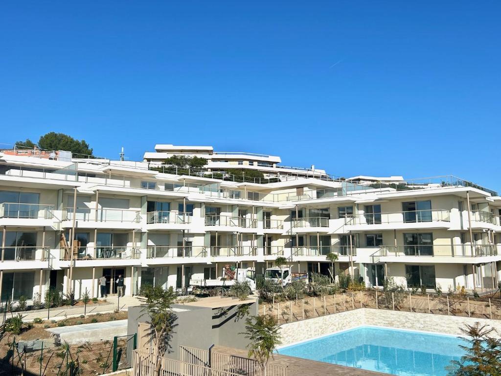 Il propose un grand appartement blanc doté d'une piscine. dans l'établissement 2 pieces villeneuve loubet, à Villeneuve-Loubet