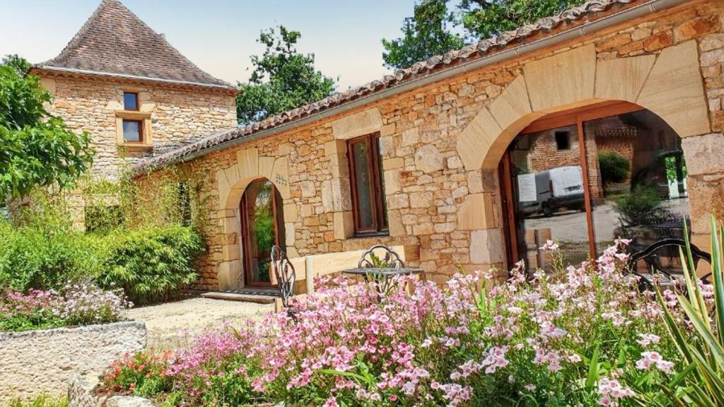 ein Steinhaus mit Garten davor in der Unterkunft Maison charmeur avec jardin à Puy-l'Évêque et piscine partagée in Puy-lʼÉvêque