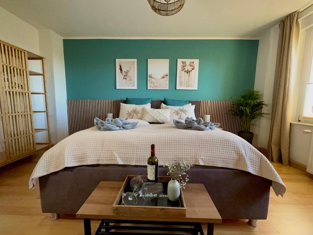 a bedroom with a bed and a table with a bottle of wine at Ferienwohnung 1 im Beachhouse am Goitzschesee - strandnah, familienfreundlich & komfortabel in Bitterfeld
