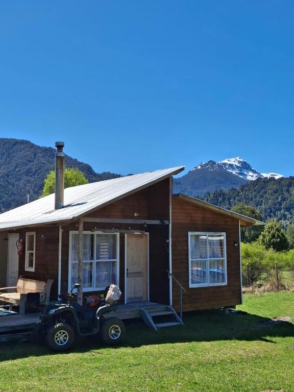 a small house with a car parked in front of it at Cabañas y tinaja El bus de chaqueihua in Hornopiren