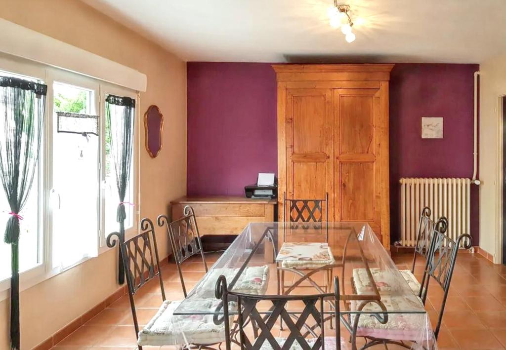 a dining room with a glass table and chairs at Maison charmante à La Flèche avec jardin et parking privé in La Flèche