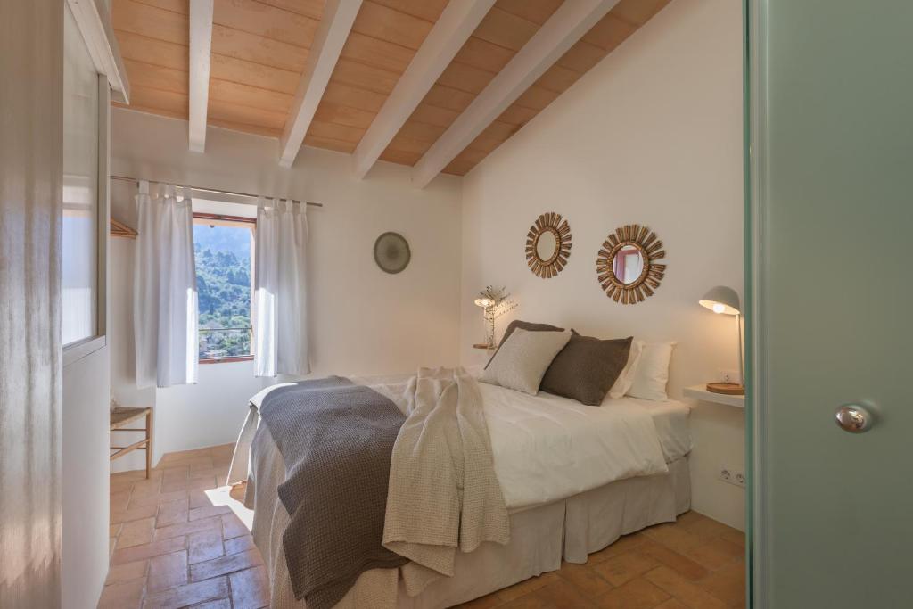Una habitación blanca con una cama y una ventana en Can Palou, en Fornalutx