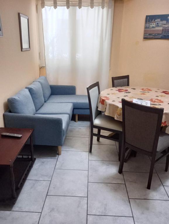 a living room with a blue couch and a table at Lo de Meli in Mar del Plata