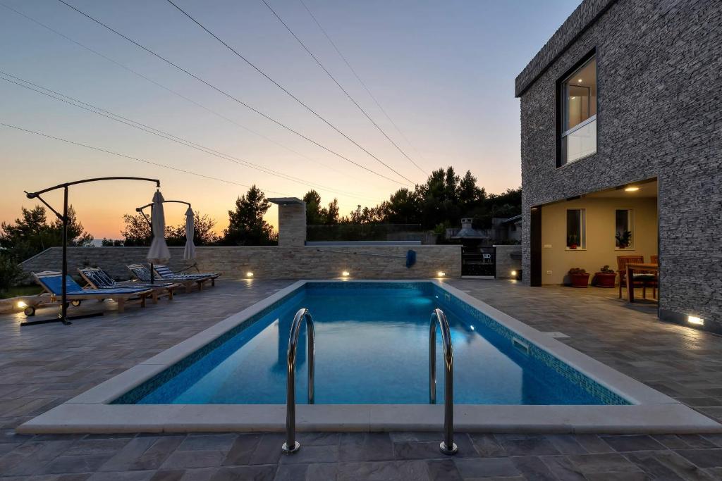a swimming pool in front of a house at Villa Infinite Joy in Makarska