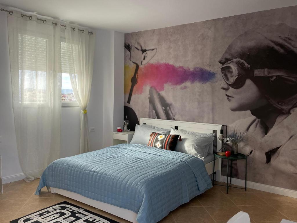 a bedroom with a bed with a painting on the wall at Panoramic Condo in Tirana! in Tirana