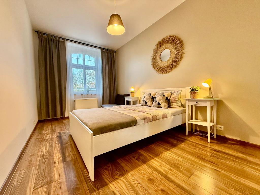Un dormitorio con una cama y una ventana grande. en Apartment Zamulkowa Katowice, en Katowice