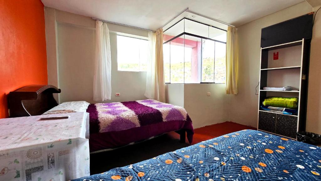 a small room with two beds and a window at Alojamiento en Puno in Puno