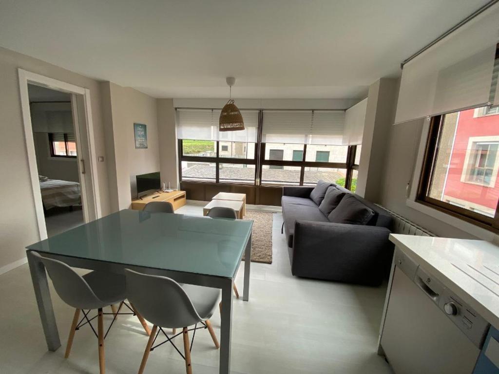 a living room with a table and a couch at Housingcoruña Apartamento Playa Miño 04 in Miño