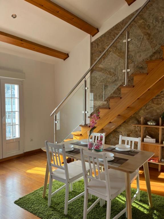 a dining room with a wooden table and chairs at La Casa de la Plaza in Cee