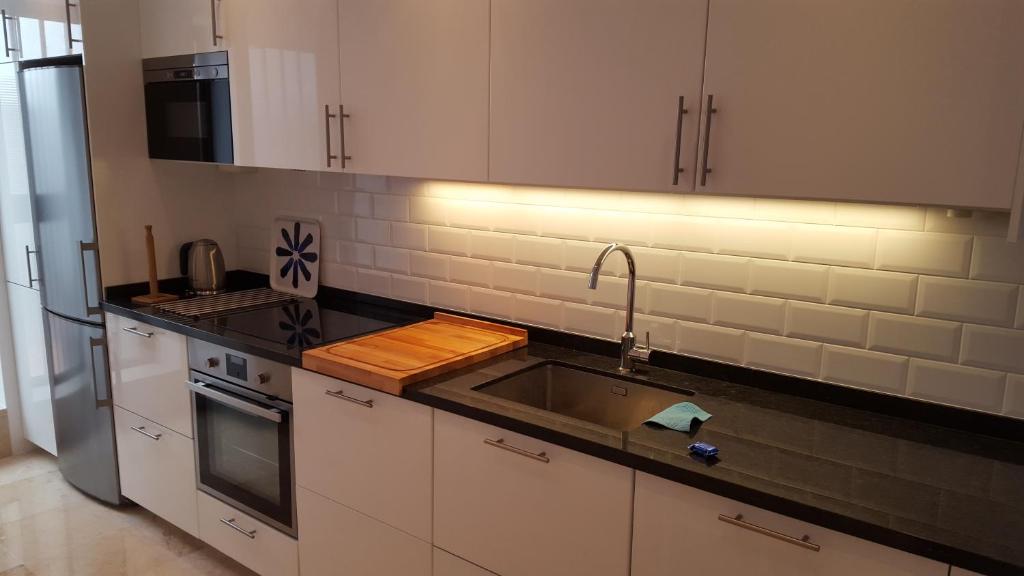a kitchen with a sink and a refrigerator at El Capistrano Sur in Nerja