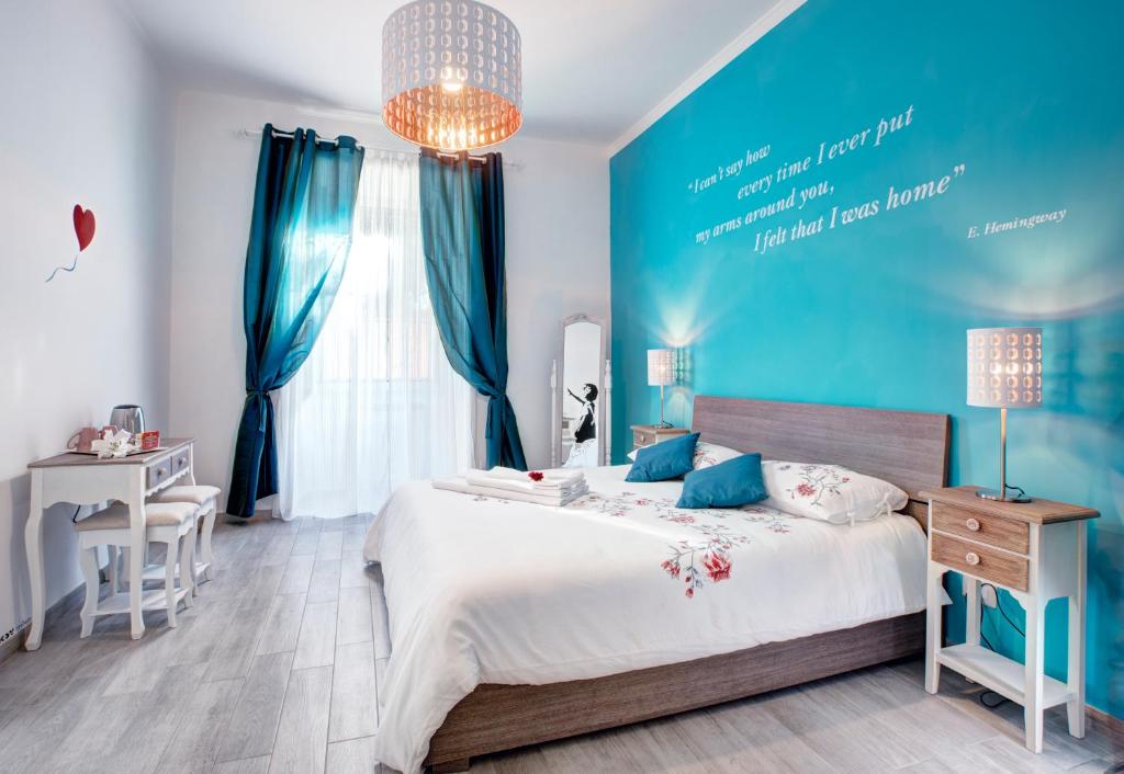 ein Schlafzimmer mit einem großen Bett und einer blauen Wand in der Unterkunft Viale del Colosseo in Rom