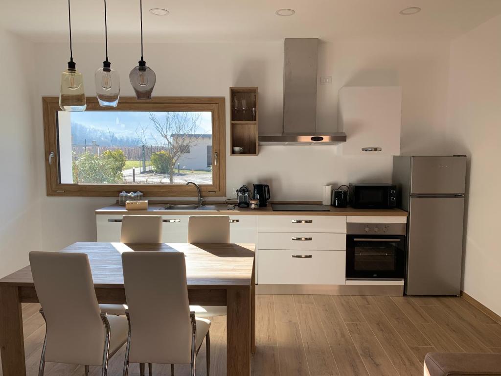 a kitchen with a table and chairs and a kitchen with a window at IL COMO' DELLA CIVETTA - Nido della Civetta in Villa di Tirano