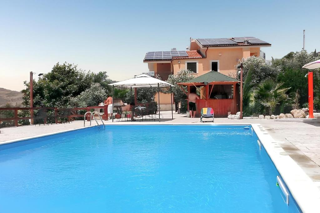 duży niebieski basen przed domem w obiekcie Spacious villa with private pool and stunning views w mieście Bompensiere