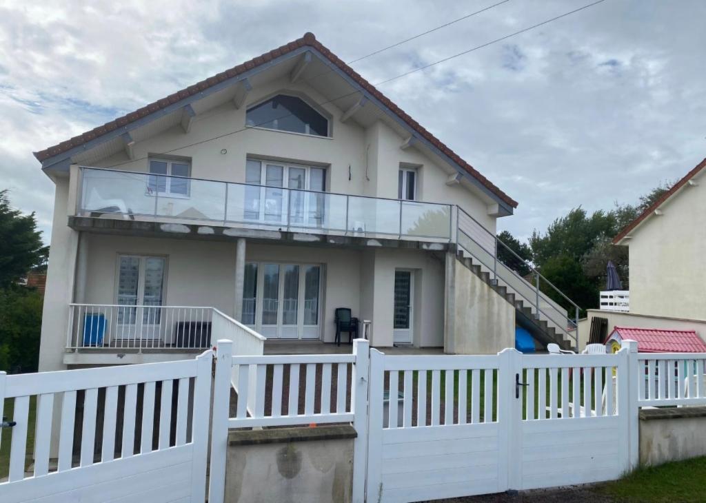 une maison avec une clôture blanche dans l'établissement Le HOME, à Varaville
