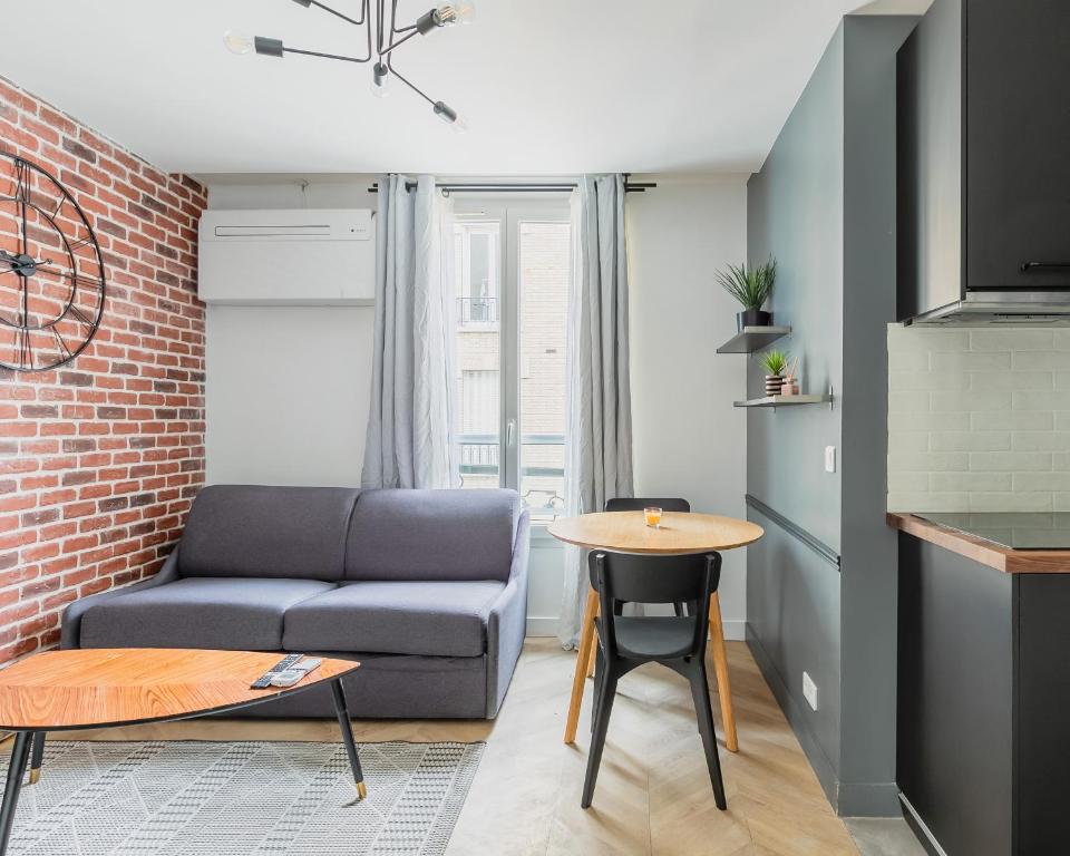 un salon avec un canapé et une table dans l'établissement unwind in timeless comfort, à Paris