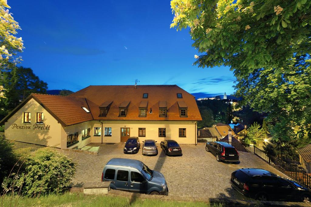 a large house with cars parked in a parking lot at Penzion Prelat in Český Krumlov
