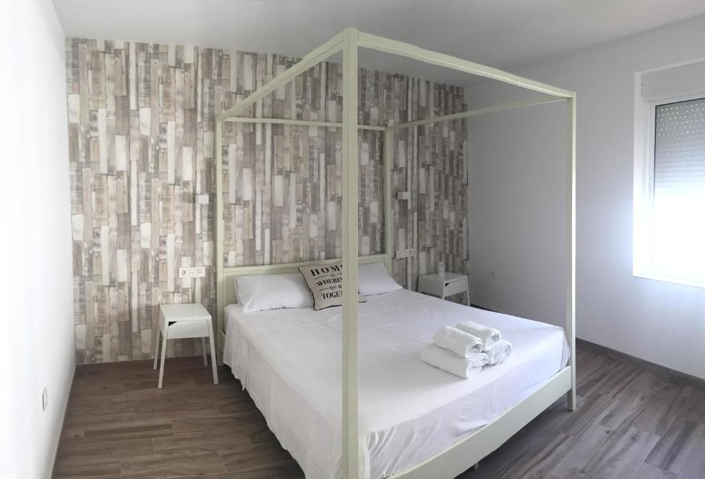 a bedroom with a white bed with a canopy at Santo Domingo Rural - Andalusian spacious house with private parking in town in Archidona