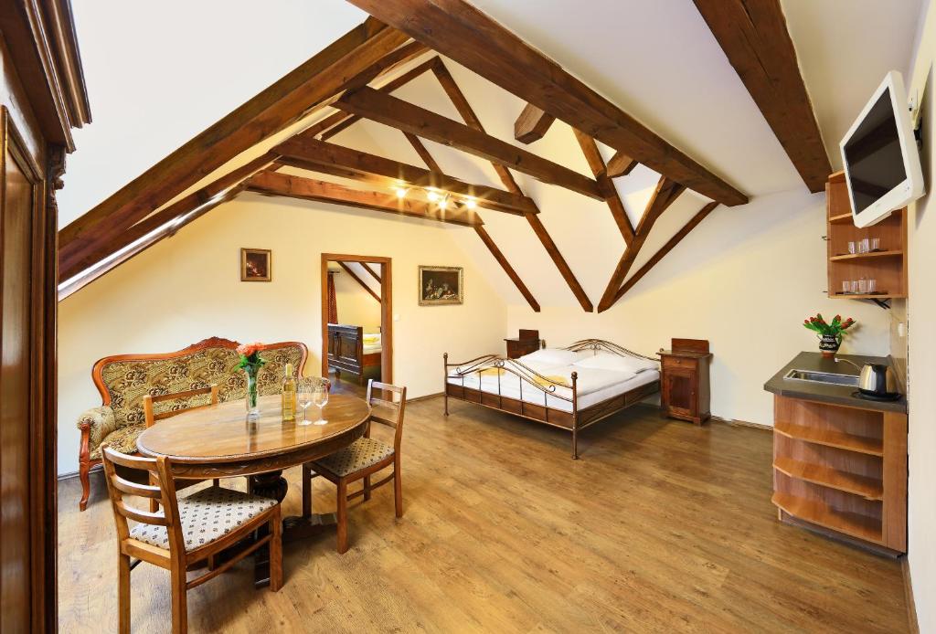 een woonkamer met een tafel en een bed bij Penzion Prelat in Český Krumlov