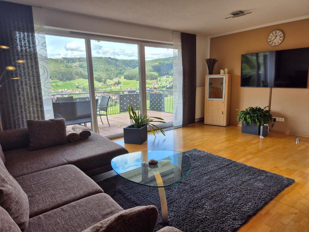 ein Wohnzimmer mit einer Couch und einem Glastisch in der Unterkunft Ferienhaus Seefried in Baiersbronn
