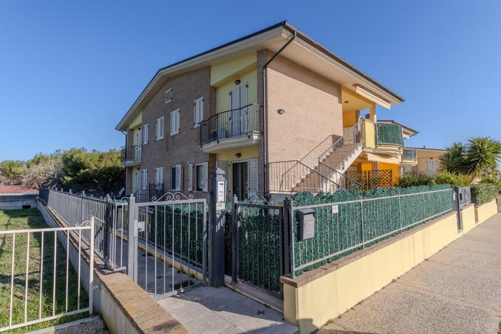 a building with a fence in front of it at Your Sea Home - Marina di Campofilone in Pedaso