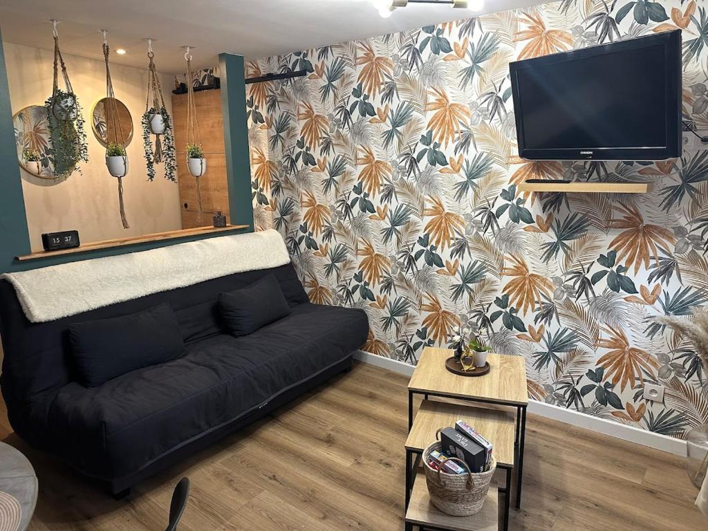 un salon avec un canapé et une télévision à écran plat dans l'établissement Maison Mers les bains, à Mers-les-Bains