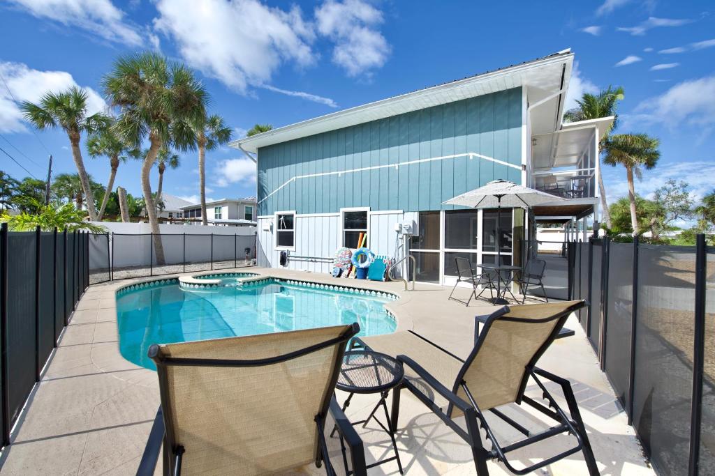 a patio with two chairs and a swimming pool at Beach Bungalow 1 by Sun Palace Vacations in Fort Myers Beach