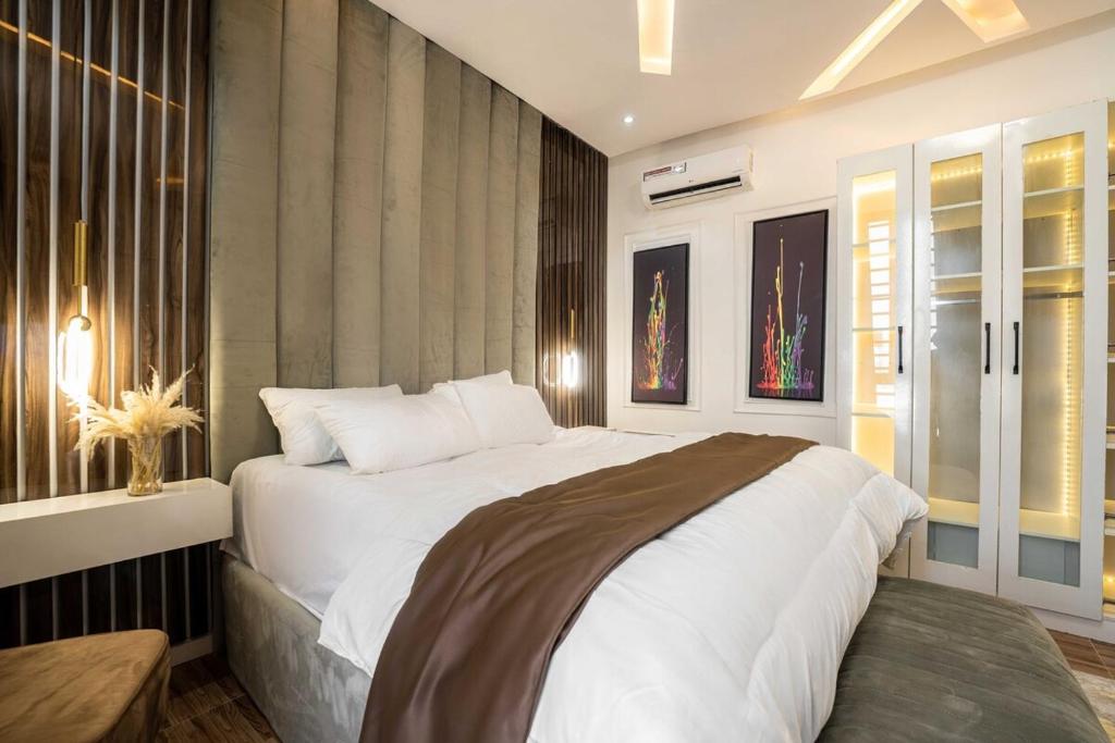una camera da letto con un grande letto bianco e una finestra di 247 Electricity 2 bedrooms Lux Ikate with PS5 opt a Lekki