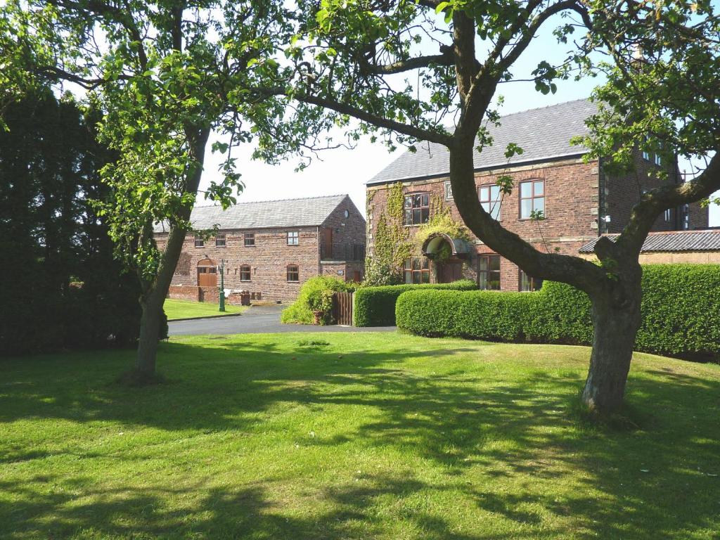 two trees in a lawn in front of a building at Parr Hall Farm, Eccleston in Chorley