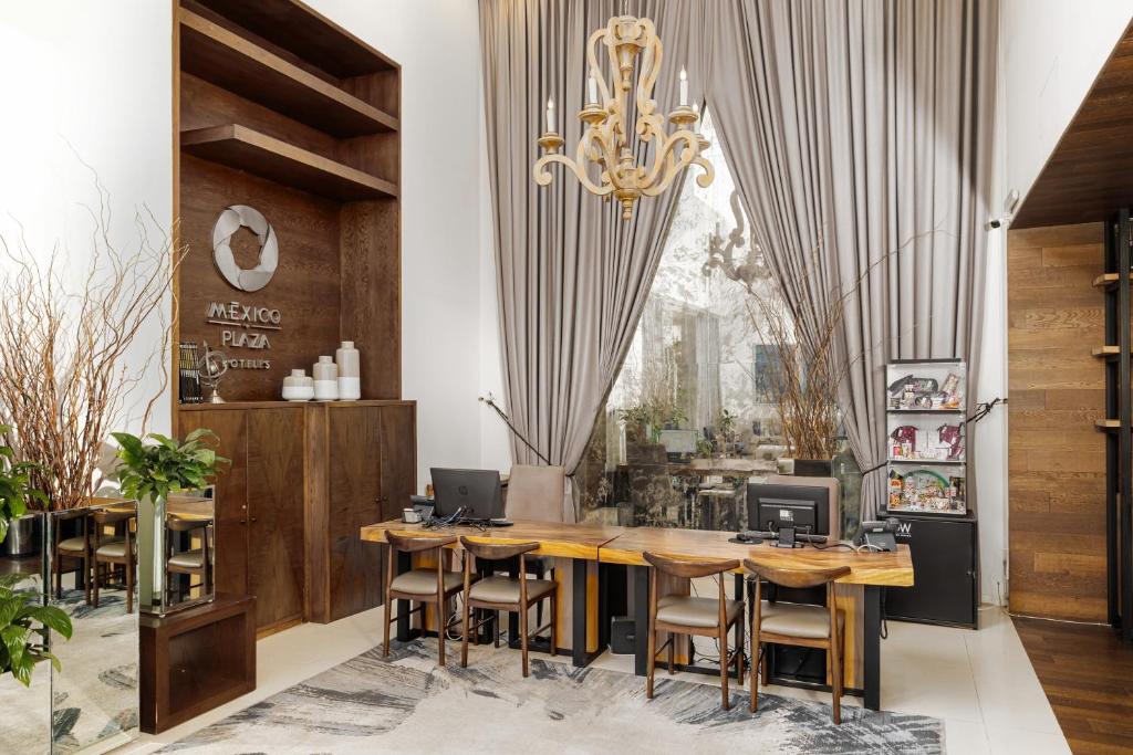 レオンにあるHotel Suites México Plaza León Campestreのダイニングルーム(木製のテーブルと椅子、シャンデリア付)