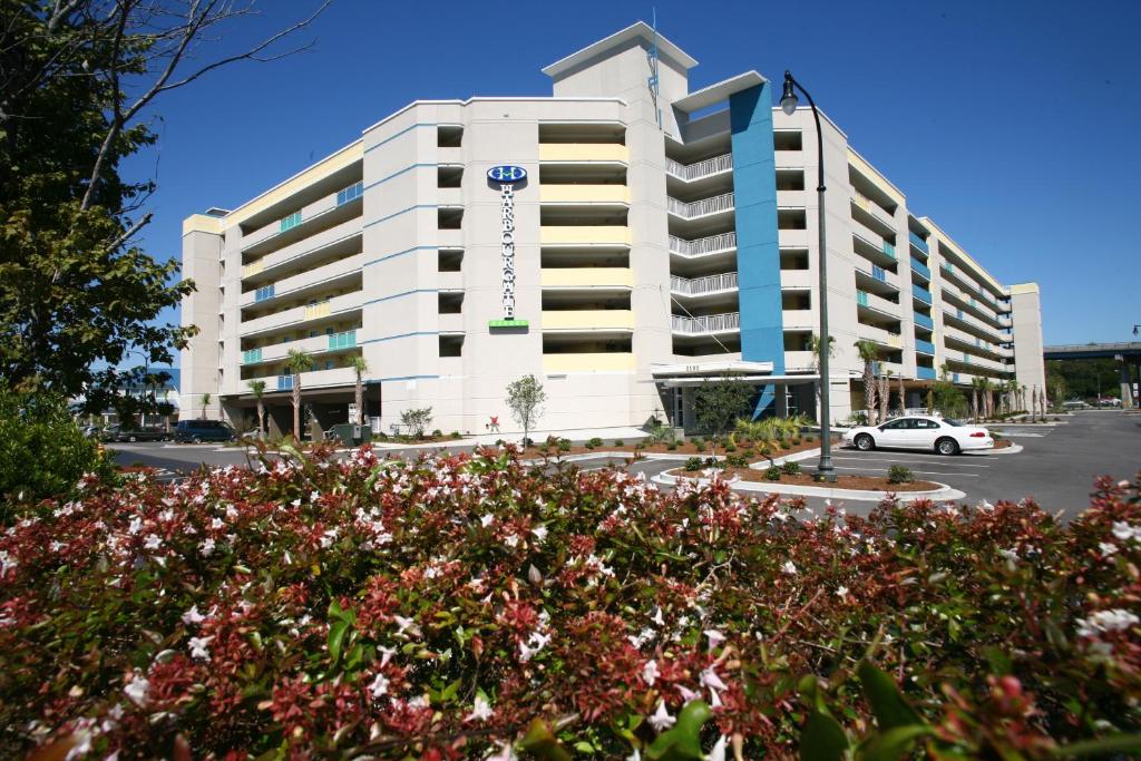 ein großes weißes Gebäude mit Blumen davor in der Unterkunft Harbourgate Marina Club in Myrtle Beach