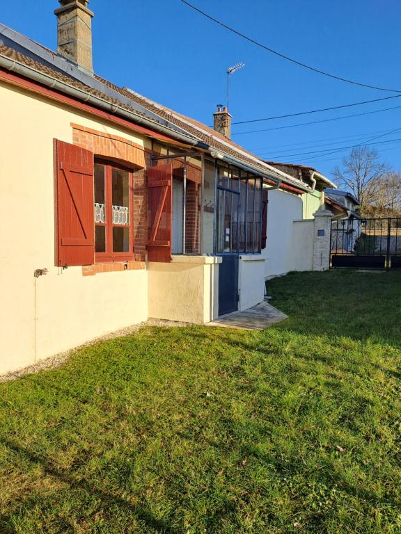 une maison avec une cour d'herbe devant elle dans l'établissement La Champenoise, à Arconville