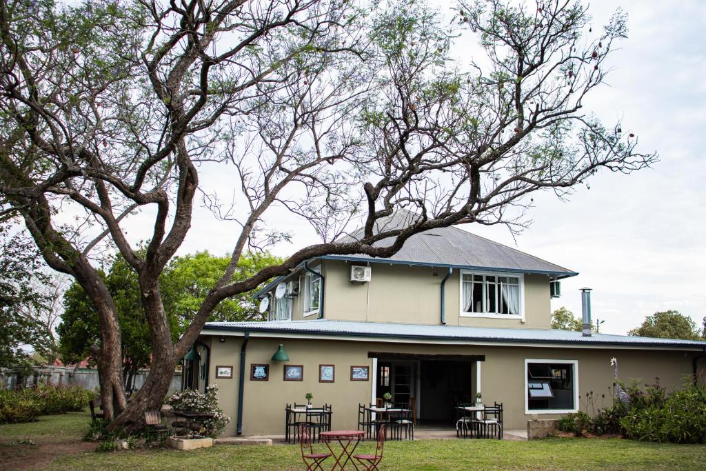 a house with tables and chairs in front of it at Colenso Lodge B&B in Colenso