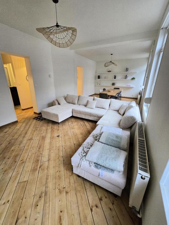 - un salon avec un canapé blanc et du parquet dans l'établissement Appartement Spacieux 4 Chambres, à Flers-en-Escrebieux