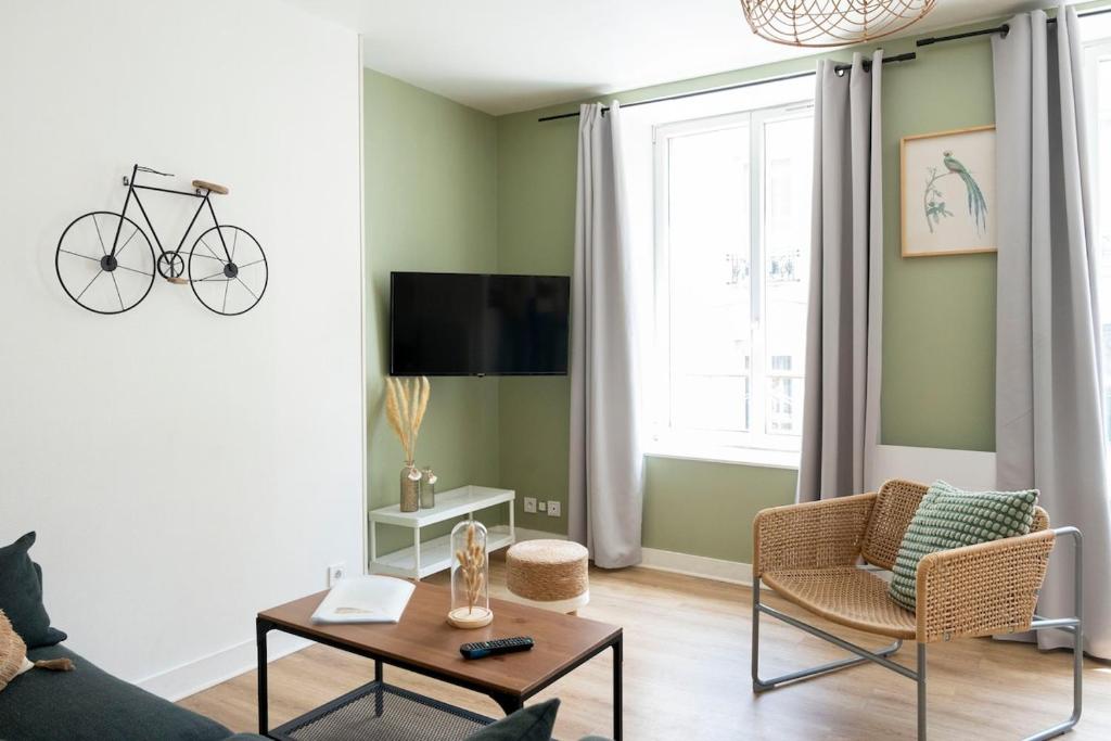 - un salon avec un vélo suspendu au mur dans l'établissement Appartement dans quartier pittoresque, à Caen