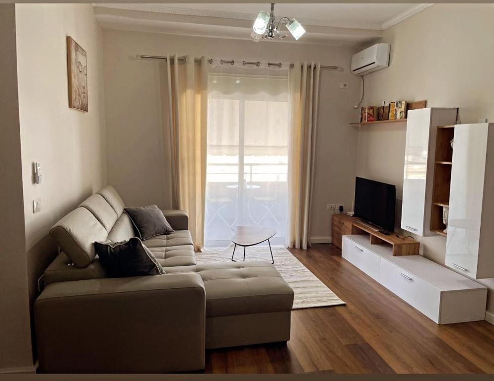 een woonkamer met een bank en een televisie bij Bliss Home in Vlorë