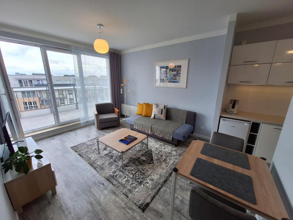 グダニスクにあるLive like a local 5th FLOOR apartmentのソファとテーブルのあるリビングルーム