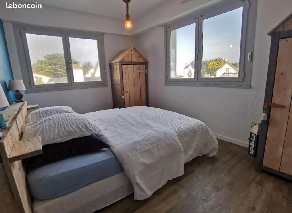 une chambre avec un lit et deux fenêtres dans l'établissement LaCabanaSGX2V, à Saint-Gilles-Croix-de-Vie