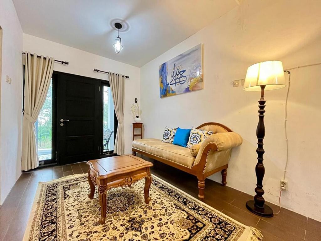 a living room with a couch and a table at Villa Al-Fatih Karangpandan in Pablengan