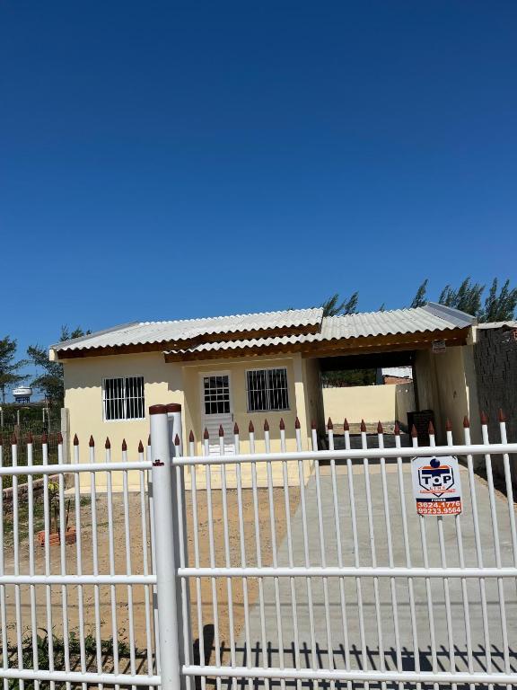 a white fence in front of a house at casa nova em imbé in Imbé
