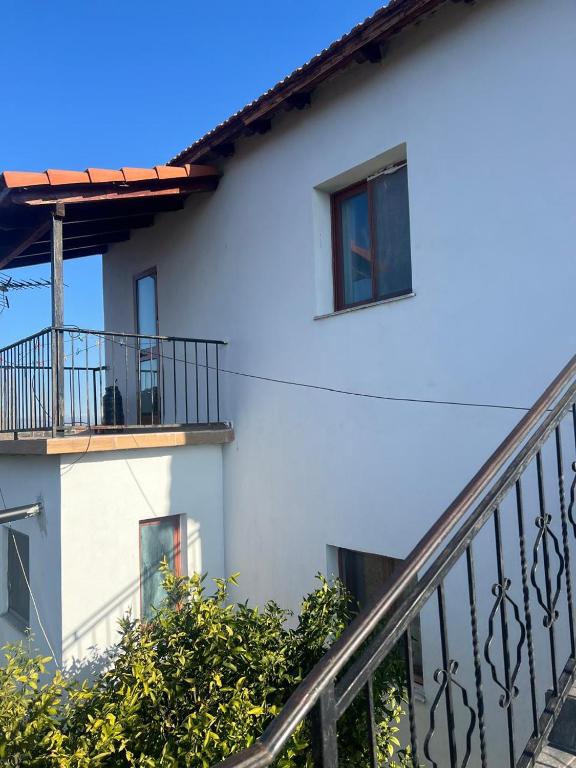 a white building with a balcony and a staircase at Bert-House close to the sea in Lezhë