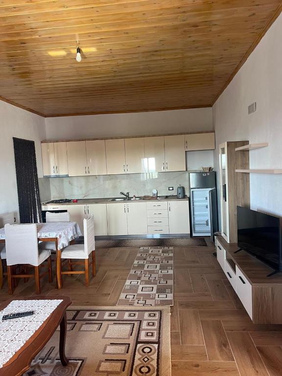 a kitchen with white cabinets and a table and chairs at Bert-House close to the sea in Lezhë