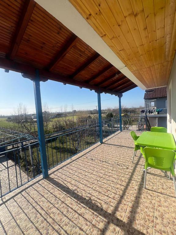 a patio with a green table and chairs on it at Bert-House close to the sea in Lezhë