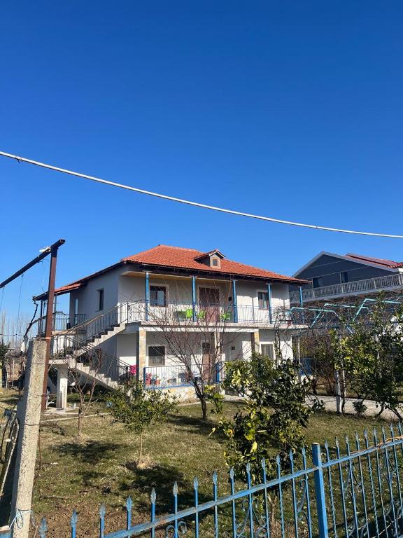 a white house with a red roof and a fence at Bert-House close to the sea in Lezhë
