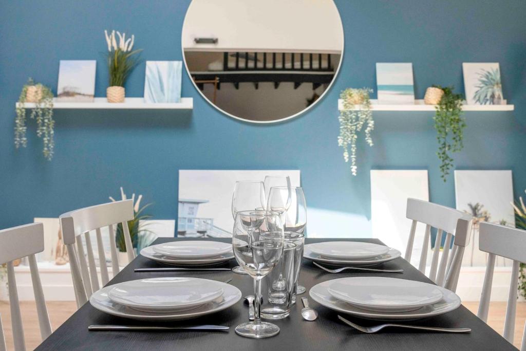 einen Esstisch mit Tellern, Gläsern und einem Spiegel in der Unterkunft Appartement proche Place Saint-Sauveur in Caen