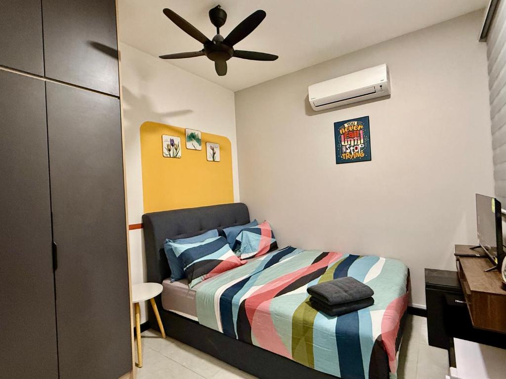 une chambre avec un lit et un ventilateur de plafond dans l'établissement Couple Suite at Neu Suites near Gleneagles, à Kuala Lumpur
