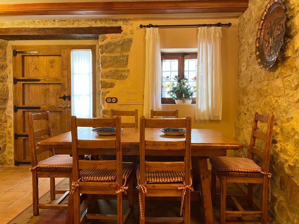 a dining room with a wooden table and chairs at CASA RURAL CARRER PLA Culla in Culla