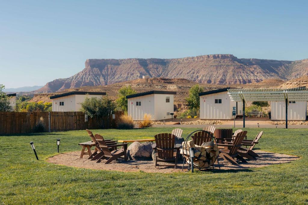 a picnic table and chairs with a mountain in the background at Zion Wildflower Resort in Virgin