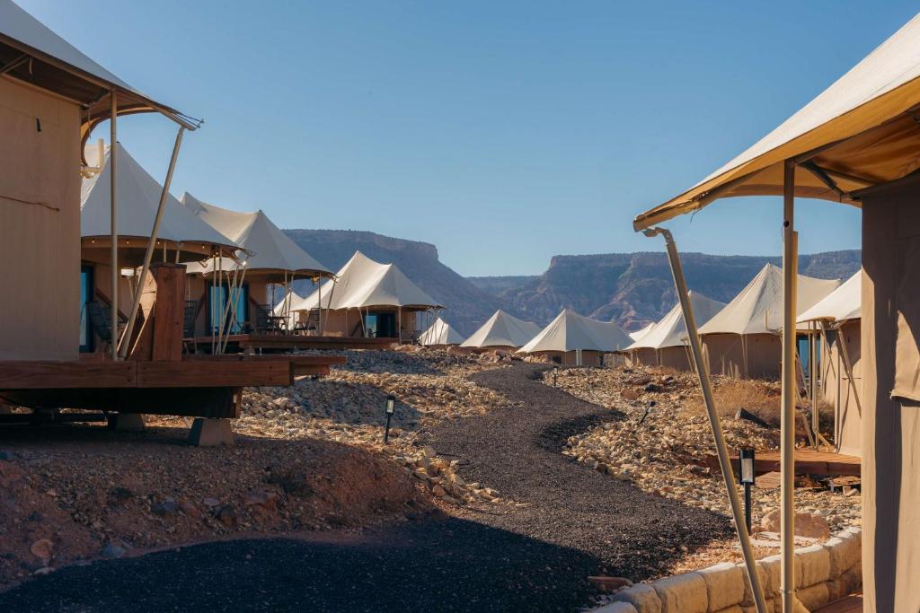 a row of tents with mountains in the background at Zion Wildflower Resort in Virgin
