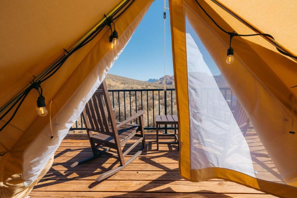 a view from the inside of a tent with a chair on a deck at Zion Wildflower Resort in Virgin