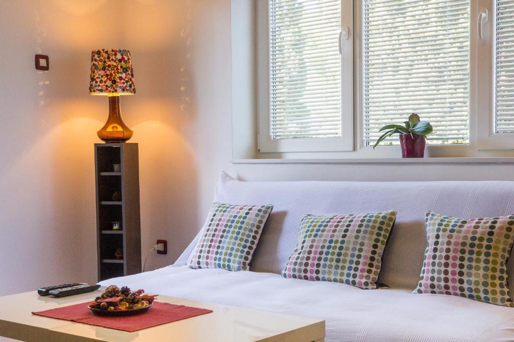 a bedroom with a white bed with pillows and a lamp at Apartment Bambi in Mali Lošinj